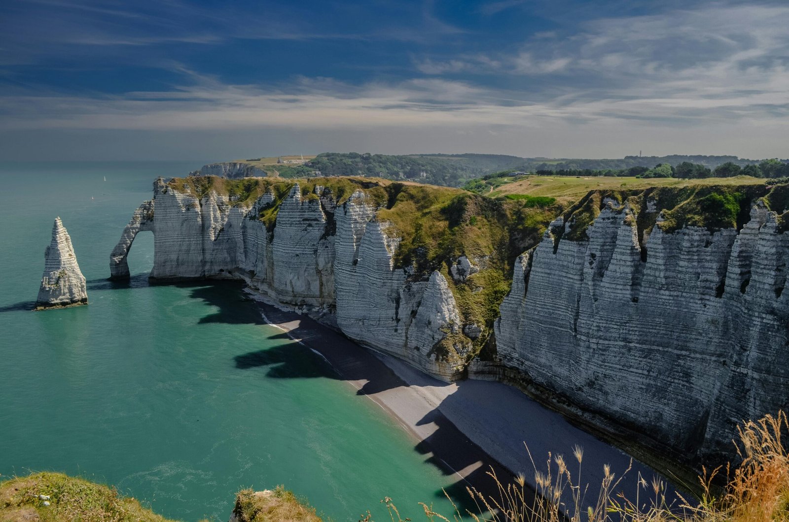 Breathtaking view of the famous white cliffs at Étretat, France, against a vibrant sea.