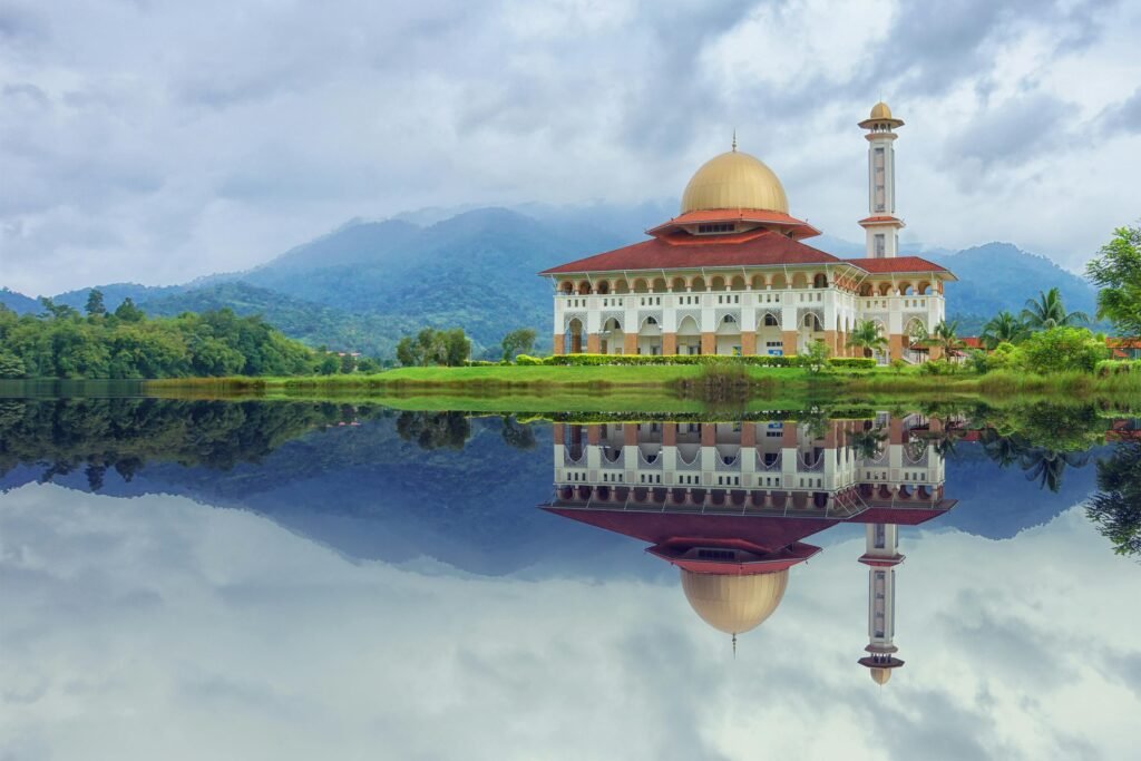 Beautiful mosque reflecting in the lake with a mountainous backdrop in Kuala Kubu Bharu, Malaysia.